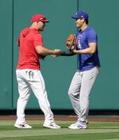 　試合前の練習で、エンゼルスのトラウト（左）と握手を交わすドジャース・大谷＝アナハイム（共同）