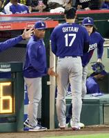 　エンゼルス戦の３回に３点二塁打を放ち、攻撃終了後にロバーツ監督（左）に迎えられるドジャース・大谷＝アナハイム（共同）