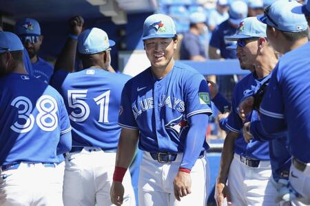　試合前、ベンチで笑顔を見せるブルージェイズ・岡本（中央）＝ダンイーデン（共同）