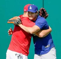 試合前の練習で、トラウト（左）とハグする（共同）