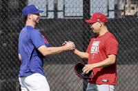 　ドジャースのタッカー（左）とあいさつを交わすエンゼルス・菊池＝ロサンゼルス（共同）