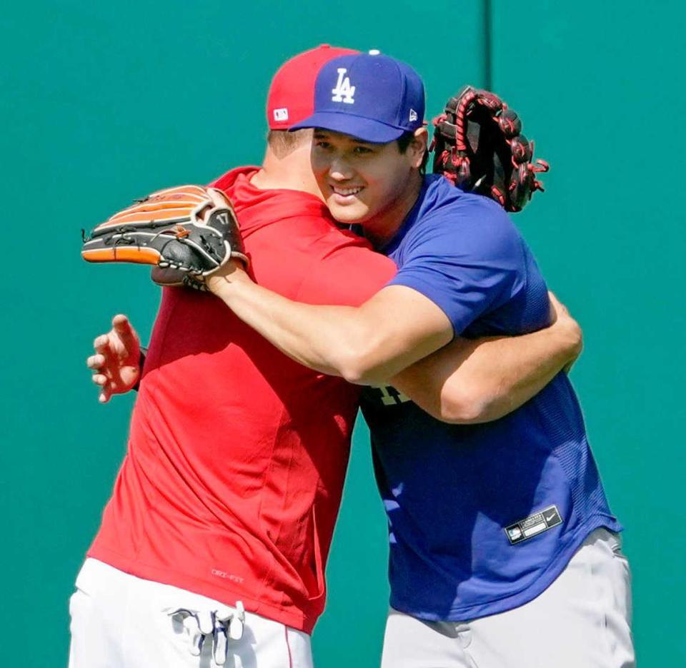 試合前の練習で、トラウト（左）とハグする（共同）