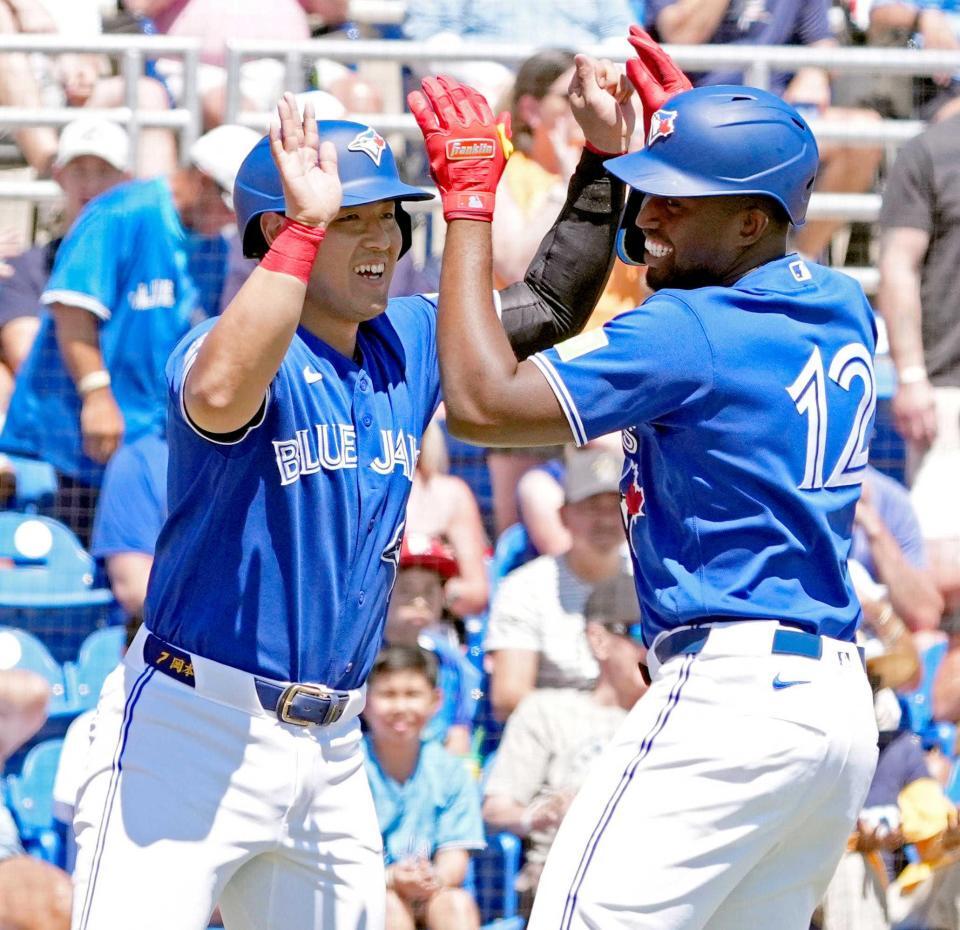 　１回、サンチェス（右）の２ランで生還し、タッチを交わす岡本（共同）