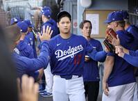 　エンゼルス戦の５回途中で降板し、ベンチで迎えられるドジャース先発の大谷＝ロサンゼルス（共同）