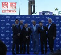 会見後の記念撮影で笑顔を見せるロバーツ監督（右から３人目）と柳井会長（同４人目）＝撮影・小林信行