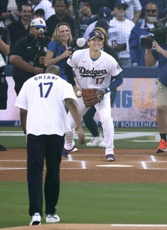 　マジック・ジョンソンさん（手前）が始球式を行い、ドジャース・大谷が捕手役を務めた＝ロサンゼルス（共同）