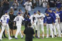 　ダイヤモンドバックスとの開幕戦に勝利し、タッチを交わす大谷（17）らドジャースの選手たち＝ロサンゼルス（共同）