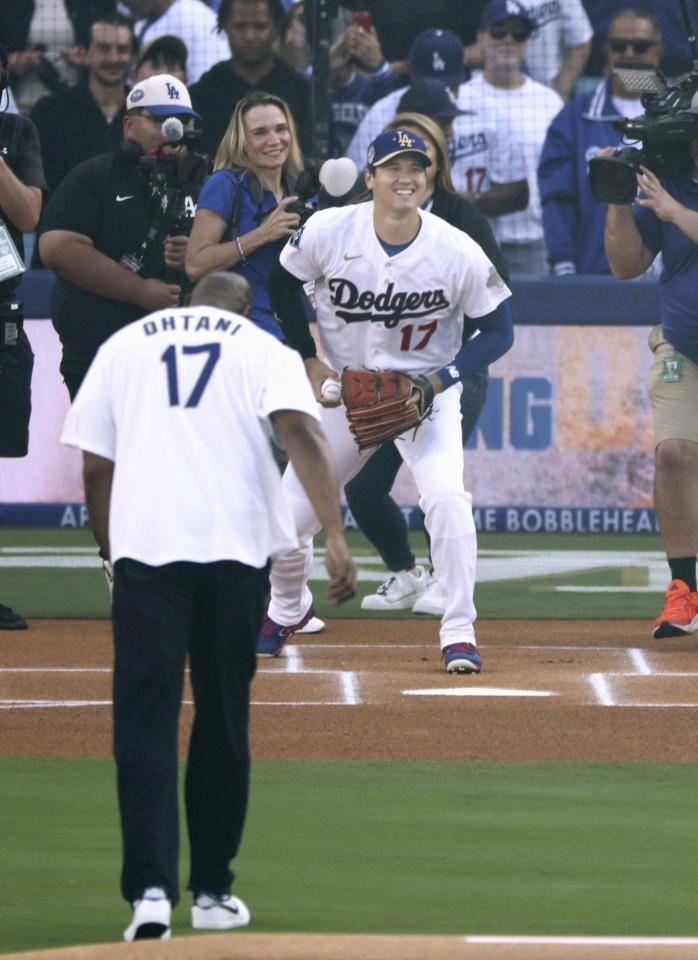 　マジック・ジョンソンさん（手前）が始球式を行い、ドジャース・大谷が捕手役を務めた＝ロサンゼルス（共同）