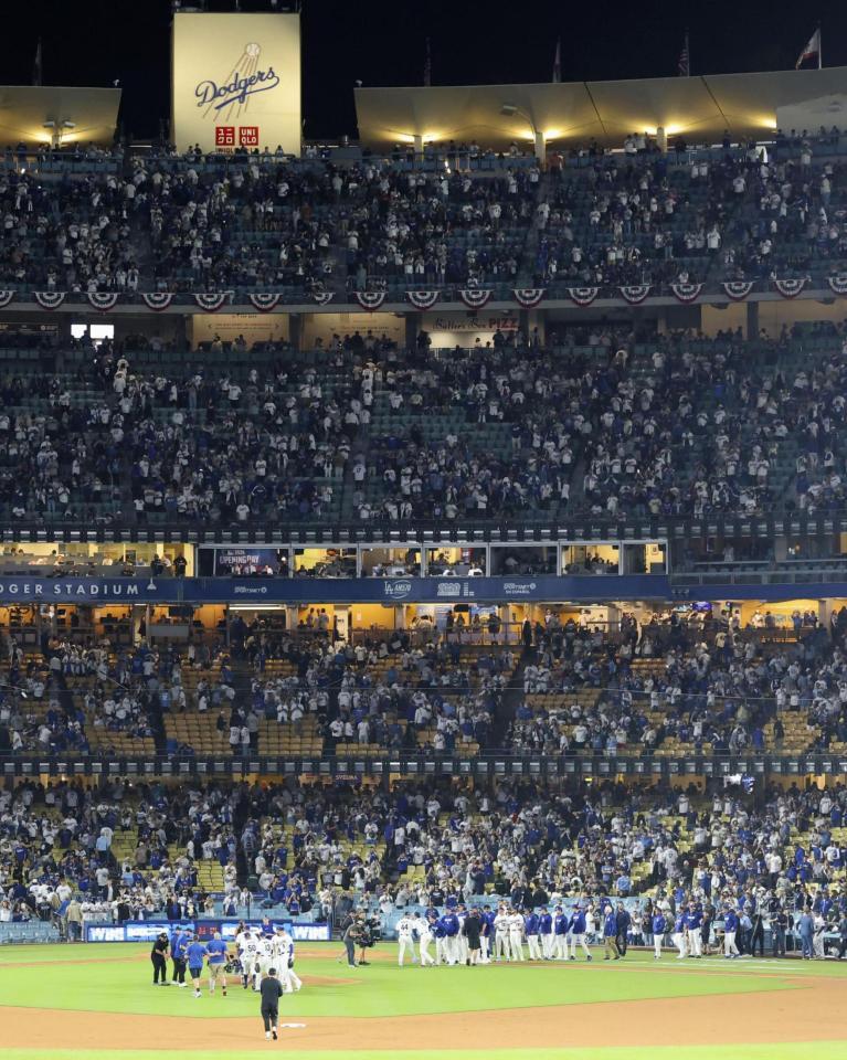 　ダイヤモンドバックスとの開幕戦に勝利し、グラウンドで喜ぶドジャースの選手ら＝ロサンゼルス（共同）