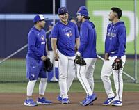 　試合前練習で、チームメートと談笑する岡本（左から２人目）＝トロント（共同）