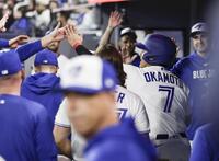 アスレチックス戦の７回、メジャー初安打を放ち、後続のゴロでアウトになった後、ベンチに戻り迎えられる岡本（７）＝トロント（共同）