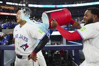 アスレチックスにサヨナラ勝ちし、試合後にゲレロ（右）から手荒い祝福を受ける岡本＝トロント（カナダ通信・ＡＰ＝共同）