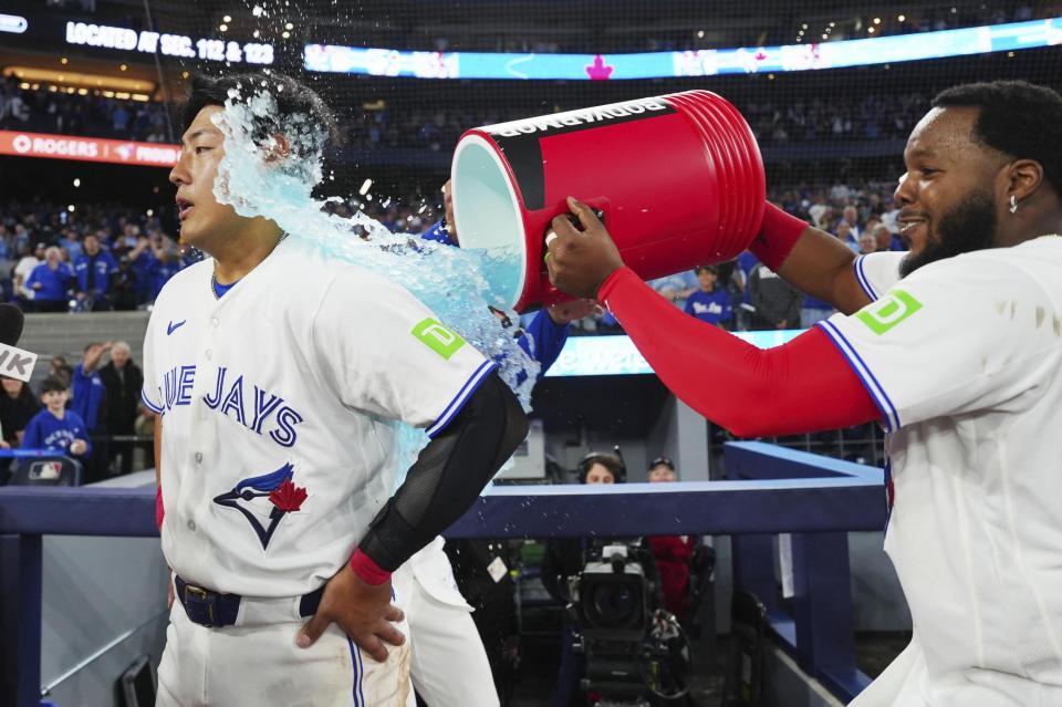 アスレチックスにサヨナラ勝ちし、試合後にゲレロ（右）から手荒い祝福を受ける岡本＝トロント（カナダ通信・ＡＰ＝共同）