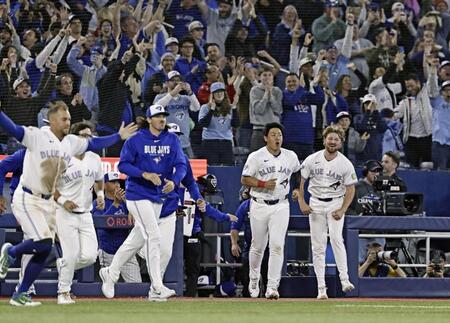 サヨナラ勝ちし、ベンチから飛び出す岡本（右から２人目）ら＝共同