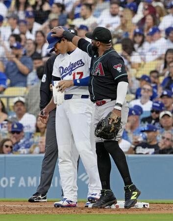 １回、四球で出塁し一塁手サンタナ（右）にちょっかいを出される大谷（共同）