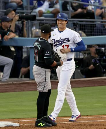 １回、四球を選び笑顔を見せる大谷。左は一塁手サンタナ（共同）