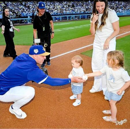 ラッシング（左）からボールを渡されるシャーロットちゃん（右）とレイトンちゃん（中央）＝ロサンゼルス・ドジャース提供