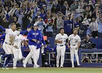 サヨナラ勝ちし、ベンチから飛び出す岡本（右から２人目）ら＝共同