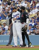 １回、四球で出塁し一塁手サンタナ（右）にちょっかいを出される大谷（共同）