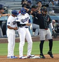 １回、四球で出塁し一塁手サンタナ（右）にちょっかいを出される大谷（共同）