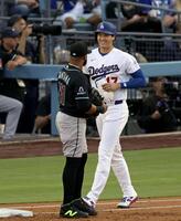 １回、四球を選び笑顔を見せる大谷。左は一塁手サンタナ（共同）