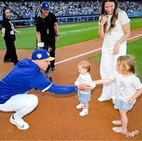 ラッシング（左）からボールを渡されるシャーロットちゃん（右）とレイトンちゃん（中央）＝ロサンゼルス・ドジャース提供