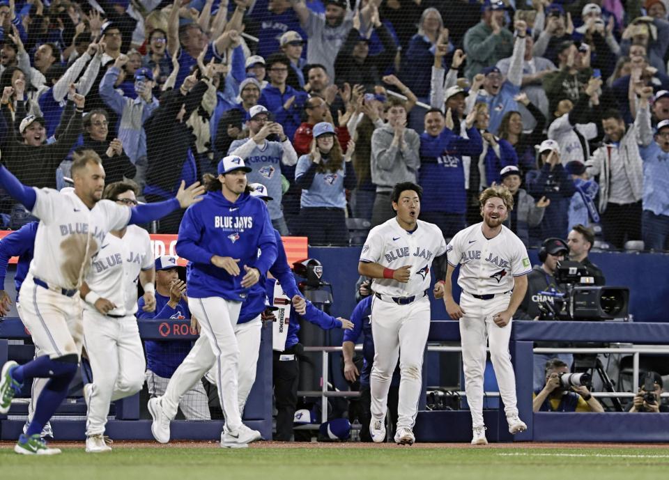 サヨナラ勝ちし、ベンチから飛び出す岡本（右から２人目）ら＝共同