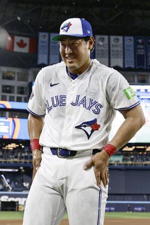 試合後に水をかけられる手荒い祝福を受け、笑顔の岡本（共同）