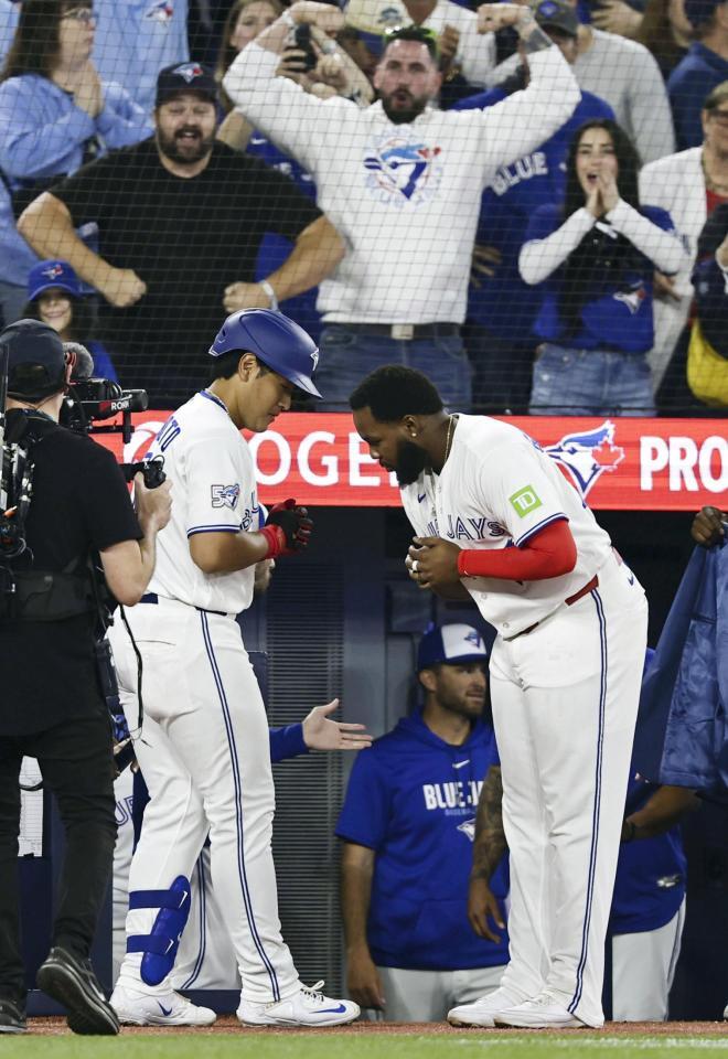 ４回、メジャー初本塁打を放ちゲレロ（右）に迎えられる岡本（共同）