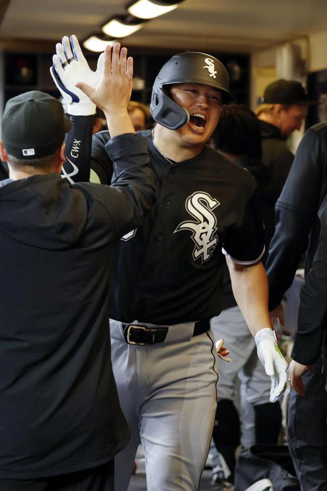 ２回に３号ソロを放ち、ベンチでタッチを交わす村上（共同）