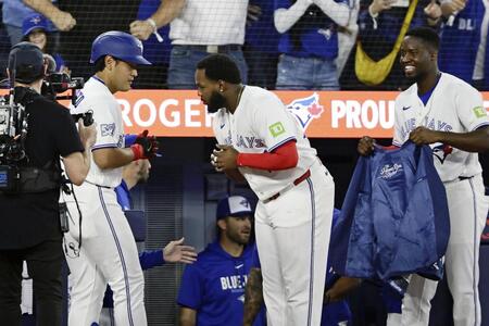 ４回、メジャー初本塁打を放ちゲレロ（中央）に迎えられる岡本（左）＝共同