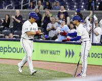 ９回、２号ソロを放ち迎えられる岡本（左）＝共同