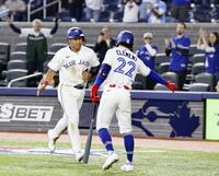 ９回、２号ソロを放ち次打者（右）に迎えられる岡本（共同）