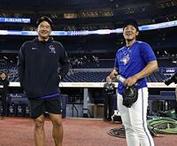 試合前、言葉を交わす岡本（右）と菅野（共同）