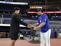 試合前、握手を交わす岡本（右）と菅野（共同）