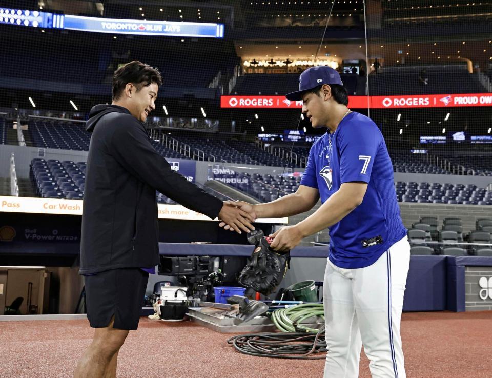 試合前、握手を交わす岡本（右）と菅野（共同）