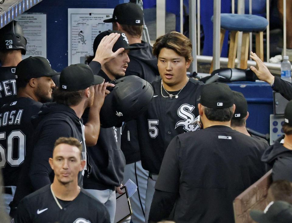 ３回の攻撃を終え、ベンチでタッチを交わす村上（共同）