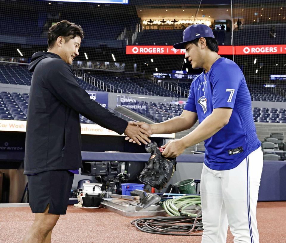 　試合前、握手を交わす岡本（右）と菅野（共同）