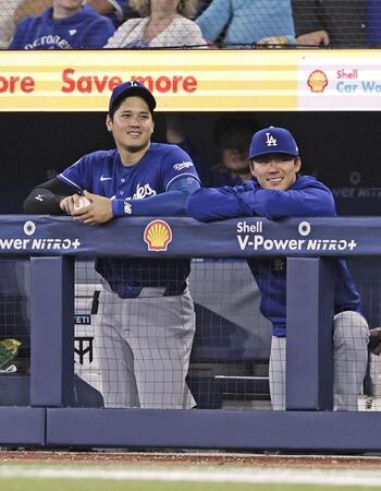 ９回、ベンチで笑顔を見せるドジャースの大谷（左）と山本（共同）