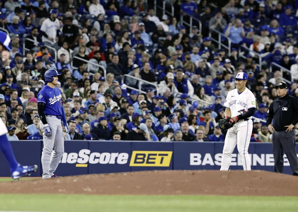 　３回、三塁に進み笑顔を見せるドジャース・大谷（左）とブルージェイズの三塁手岡本＝トロント（共同）