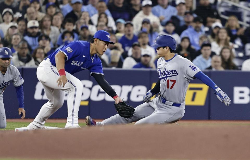 　ブルージェイズ戦の１回、後続のフライで三塁に滑り込むドジャースの二走大谷。左は三塁手岡本＝トロント（共同）