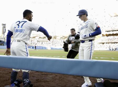 　レンジャーズ戦の１回、先頭打者本塁打を放ち、Ｔ・ヘルナンデス（左）に迎えられるドジャース・大谷＝ロサンゼルス（共同）