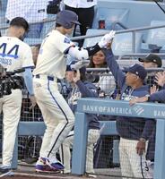 　レンジャーズ戦の１回、先頭打者本塁打を放ちロバーツ監督（手前右）に迎えられるドジャース・大谷＝ロサンゼルス（共同）