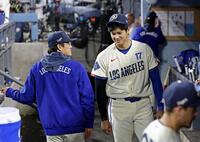 　レンジャーズ戦の９回、ベンチで山本（左）と言葉を交わすドジャース・大谷＝ロサンゼルス（共同）
