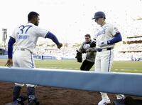 　レンジャーズ戦の１回、先頭打者本塁打を放ち、Ｔ・ヘルナンデス（左）に迎えられるドジャース・大谷＝ロサンゼルス（共同）