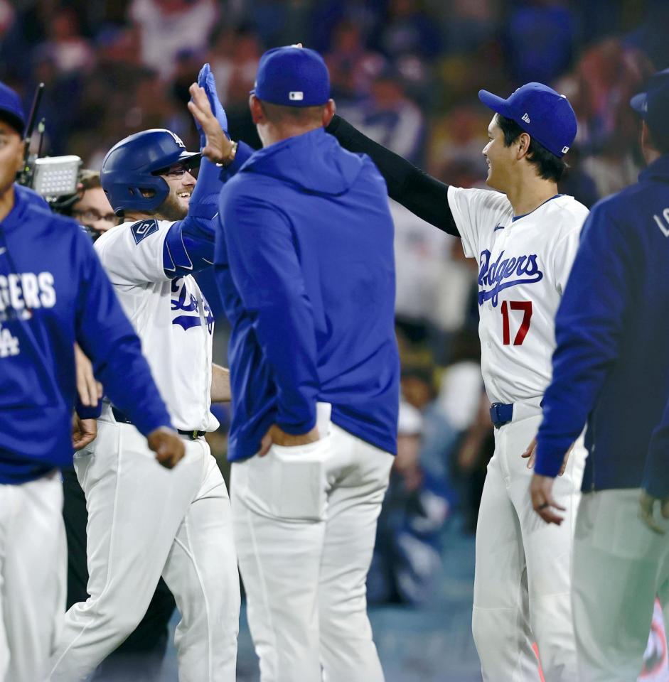 レンジャーズに勝利し、サヨナラ本塁打のマンシー（左）を迎えるドジャース・大谷（１７）＝１０日（共同）