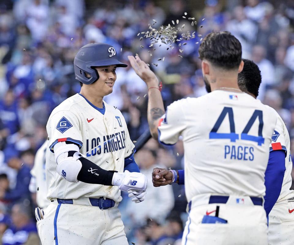 　レンジャーズ戦の１回、先頭打者本塁打を放ち迎えられるドジャース・大谷＝ロサンゼルス（共同）