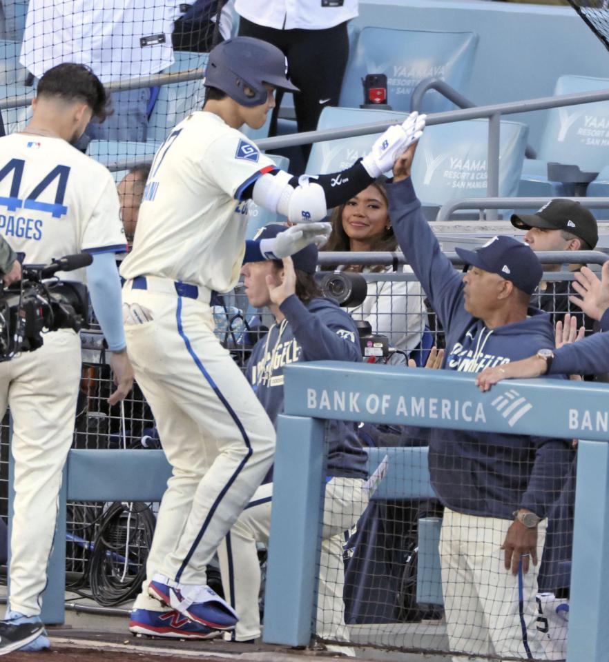 　レンジャーズ戦の１回、先頭打者本塁打を放ちロバーツ監督（手前右）に迎えられるドジャース・大谷＝ロサンゼルス（共同）