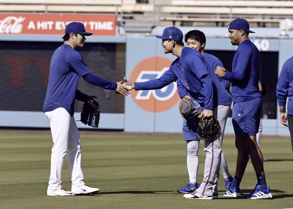 　試合前、握手を交わす山本（左）と千賀。右端はディアス＝ロサンゼルス（共同）