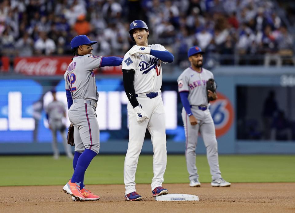 メッツ戦の１回、死球で出塁し後続の四球で二進し、遊撃手リンドア（左）と話す大谷＝ロサンゼルス（共同）